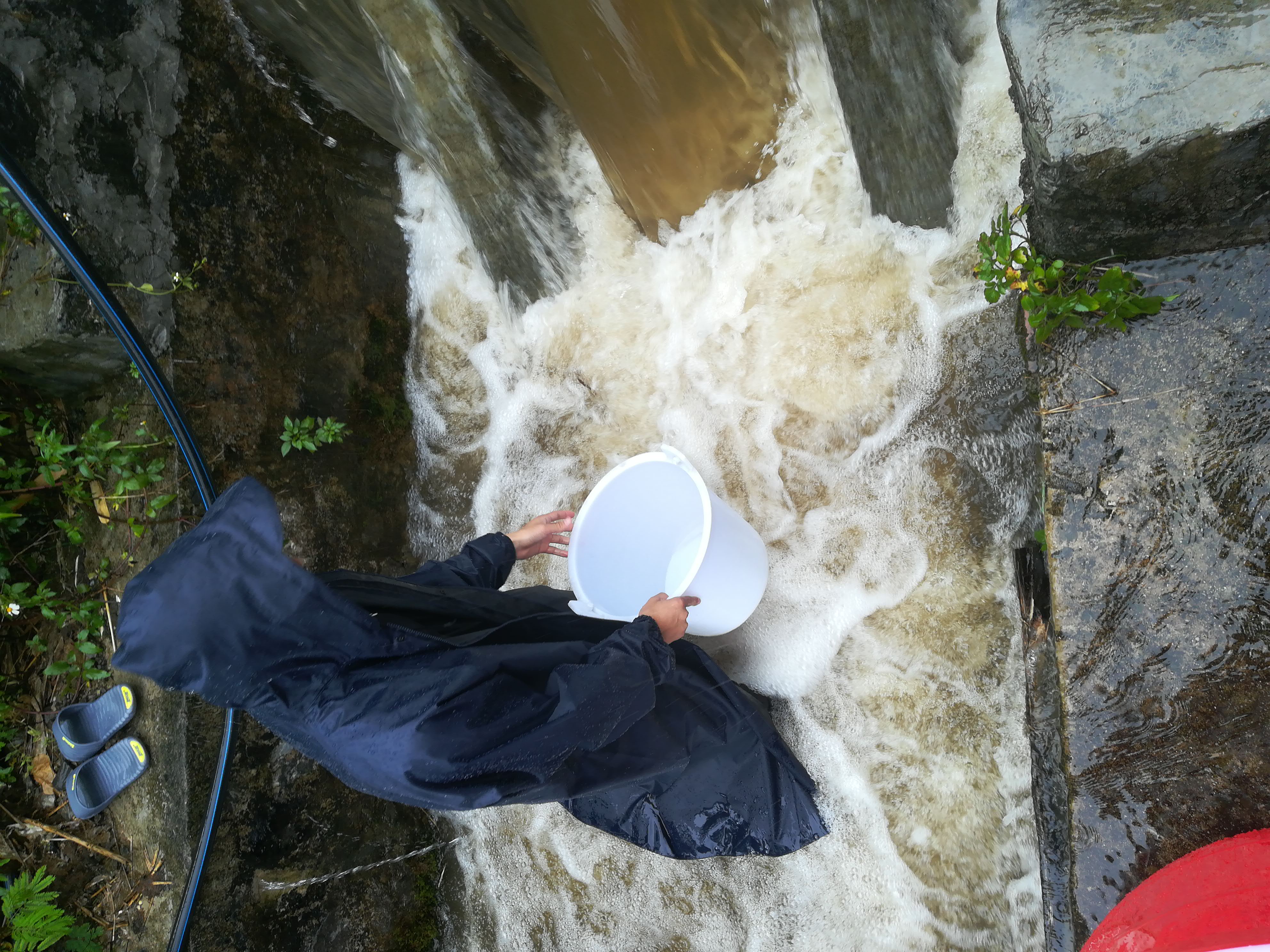 研究生张耀华暴雨中取水样（张耀华摄）